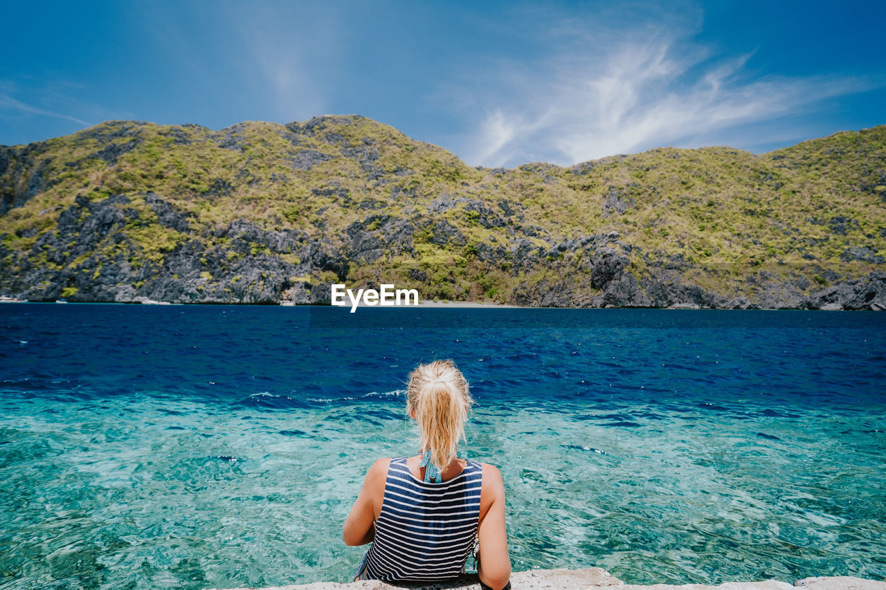 Rear view of woman in sea against sky