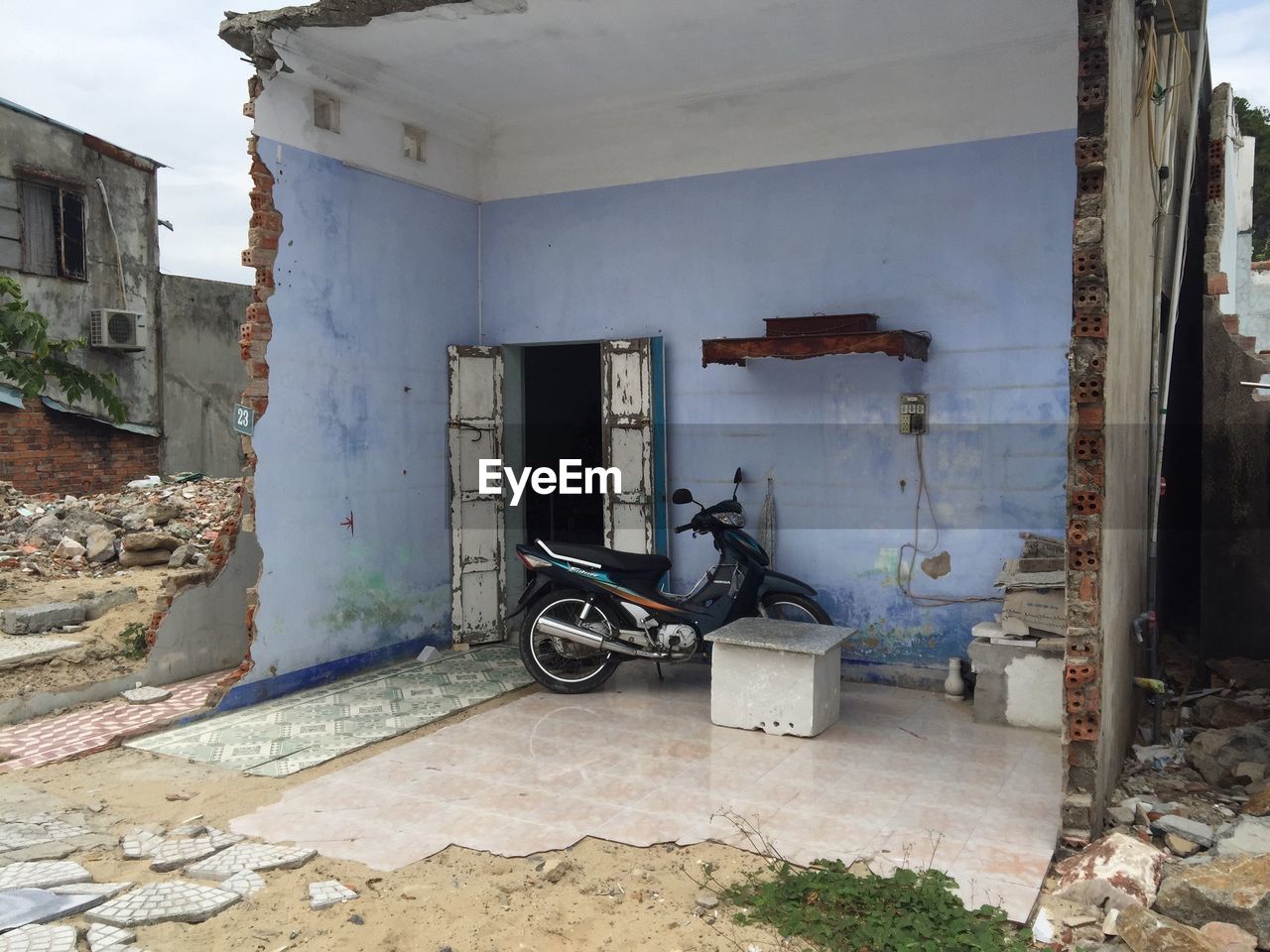 Motor scooter parked in broken house