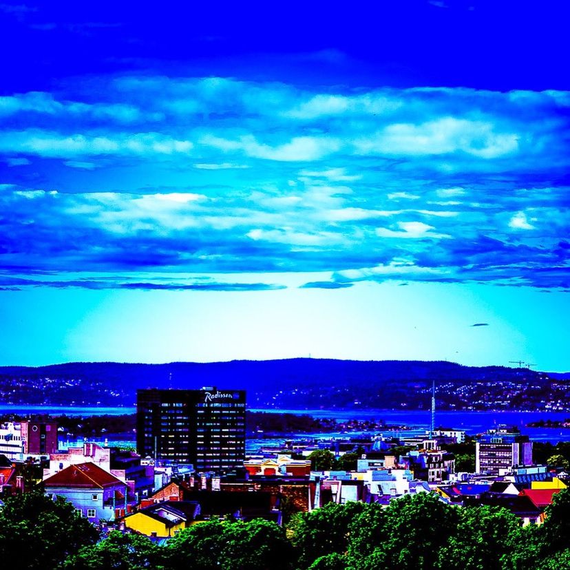 VIEW OF CITYSCAPE AGAINST CLOUDY SKY