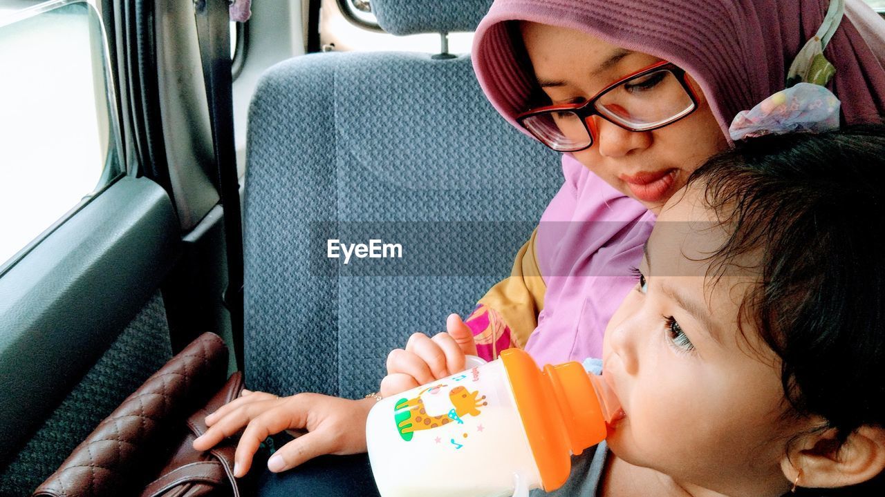 Women and her child sitting in car