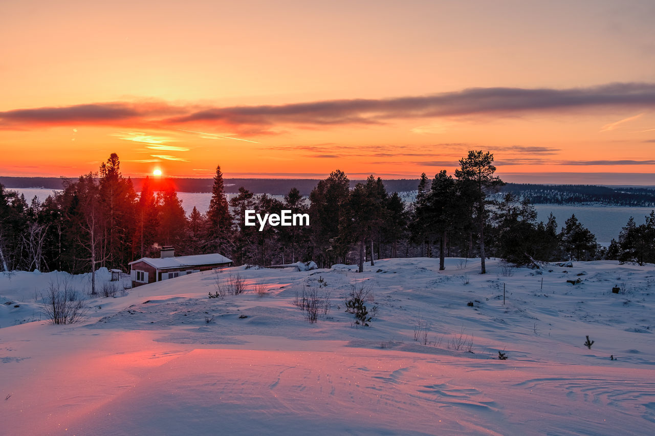 sunset, snow, winter, cold temperature, sky, landscape, environment, scenics - nature, tree, beauty in nature, nature, plant, land, sun, cloud, dawn, coniferous tree, tranquility, tranquil scene, orange color, pinaceae, evening, pine tree, frozen, forest, travel, travel destinations, mountain, no people, pine woodland, non-urban scene, rural scene, outdoors, twilight, sunlight, water, idyllic, ice, architecture, holiday, sports, vacation, tourism, woodland, blue