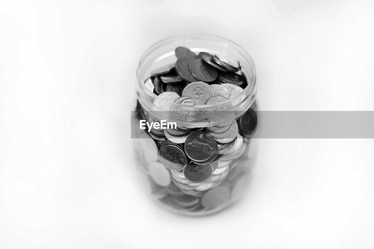 HIGH ANGLE VIEW OF GLASS JAR ON WHITE SURFACE