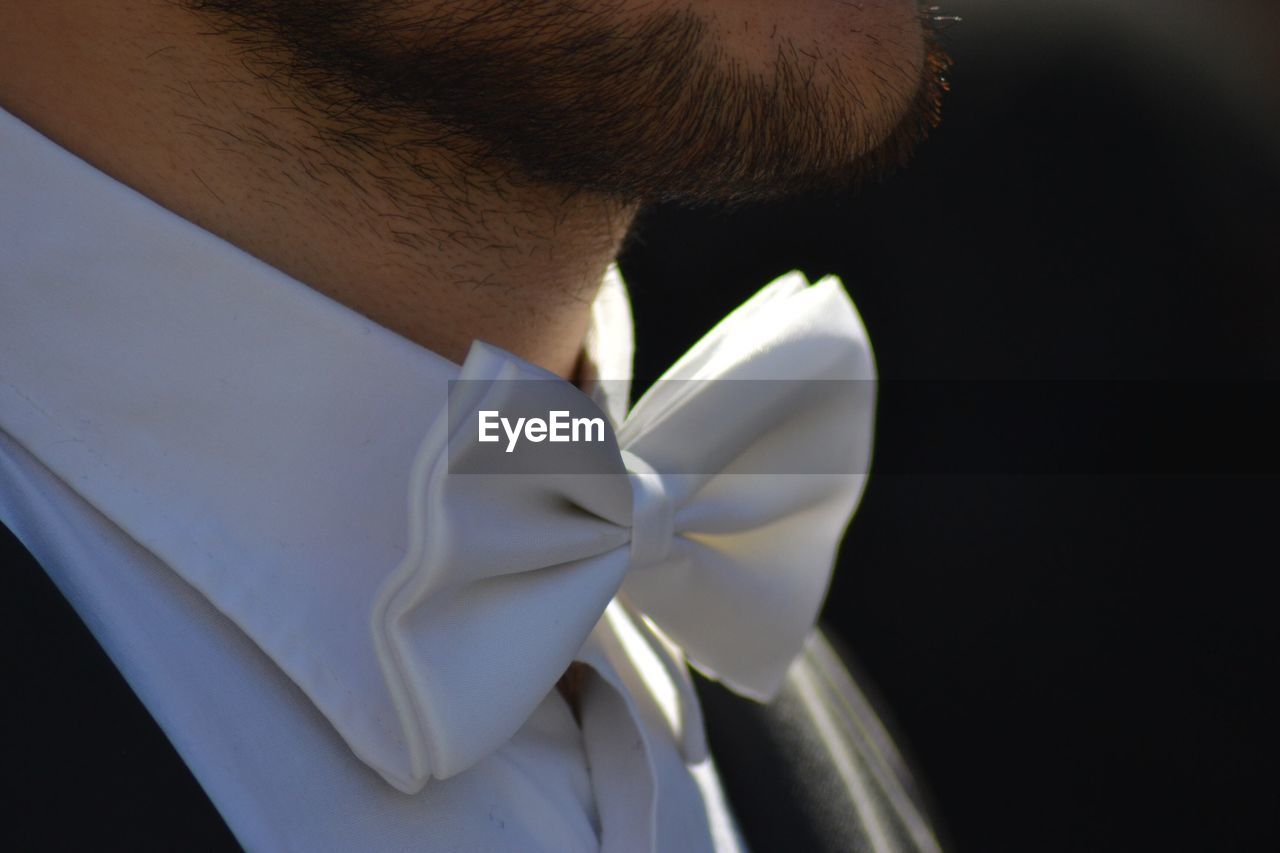 Midsection of man wearing tied bow