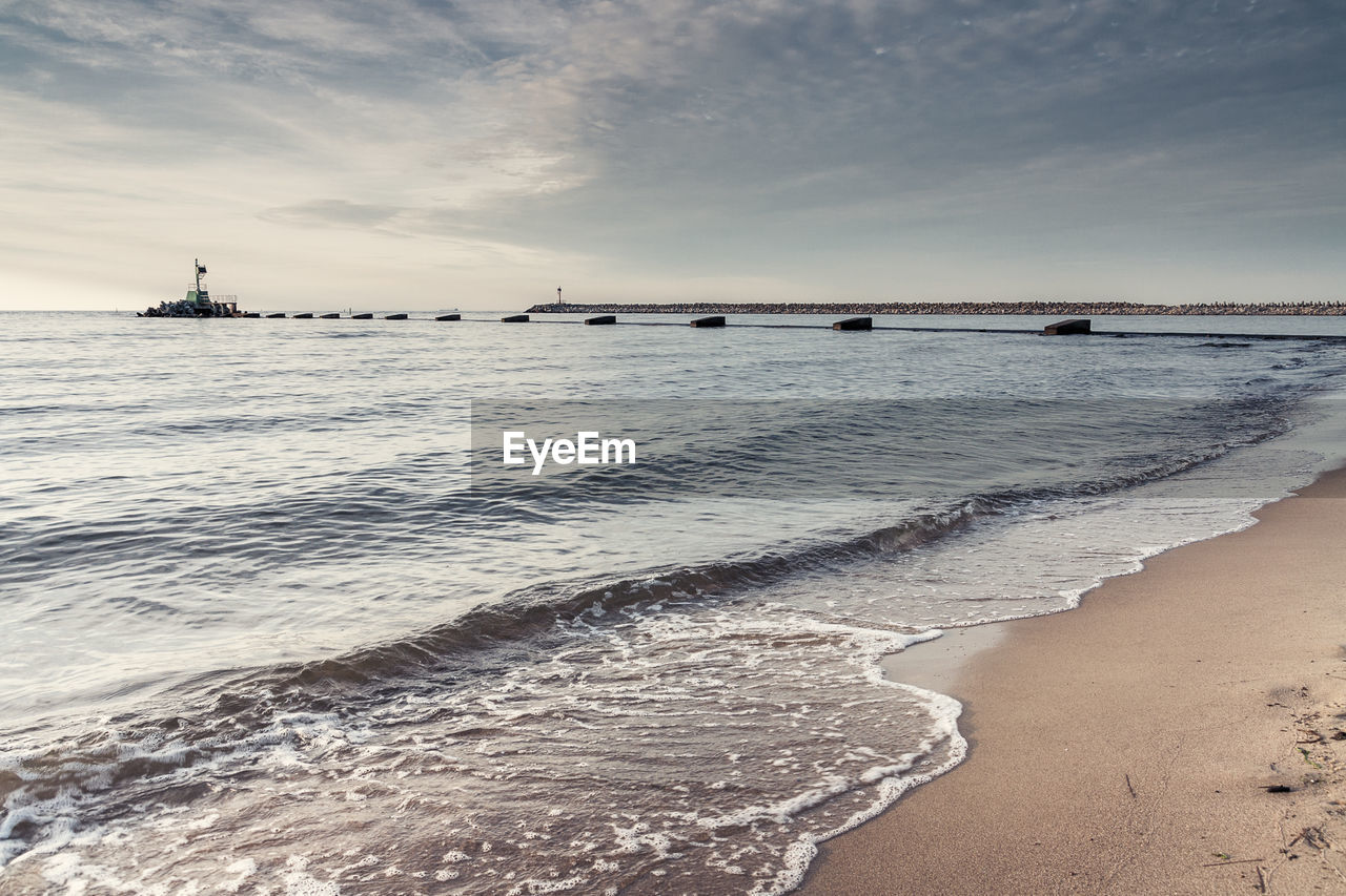 View of beach against cloudy sky