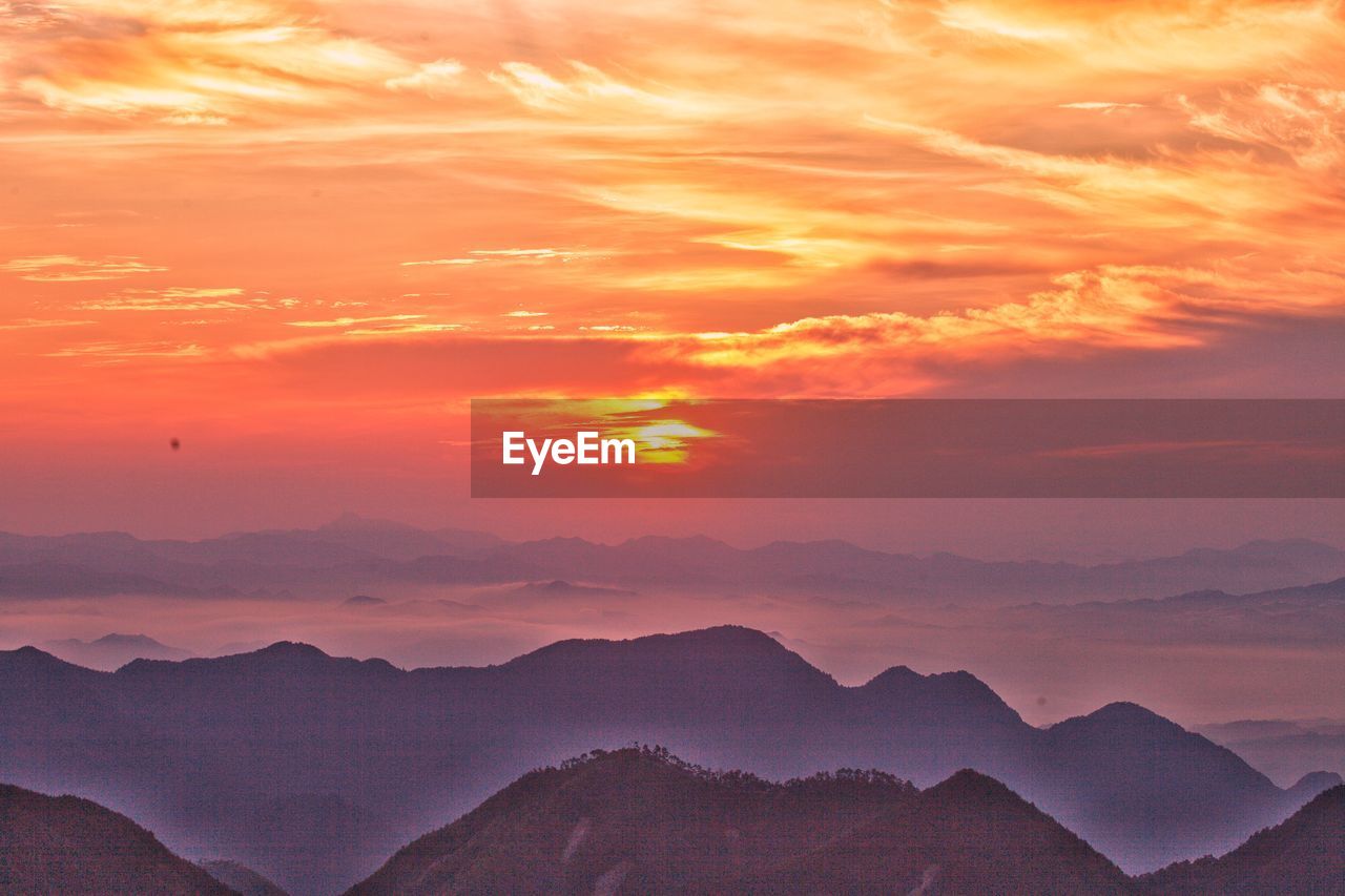 mountain, sky, sunset, environment, landscape, scenics - nature, beauty in nature, cloud, nature, mountain range, dramatic sky, dawn, sun, travel, tranquility, horizon, land, travel destinations, tranquil scene, sunlight, no people, idyllic, twilight, outdoors, afterglow, fog, tourism, cloudscape, orange color, mountain peak, awe, non-urban scene, red sky at morning, atmospheric mood, sunbeam, silhouette, evening, moody sky, red, romantic sky, rural scene
