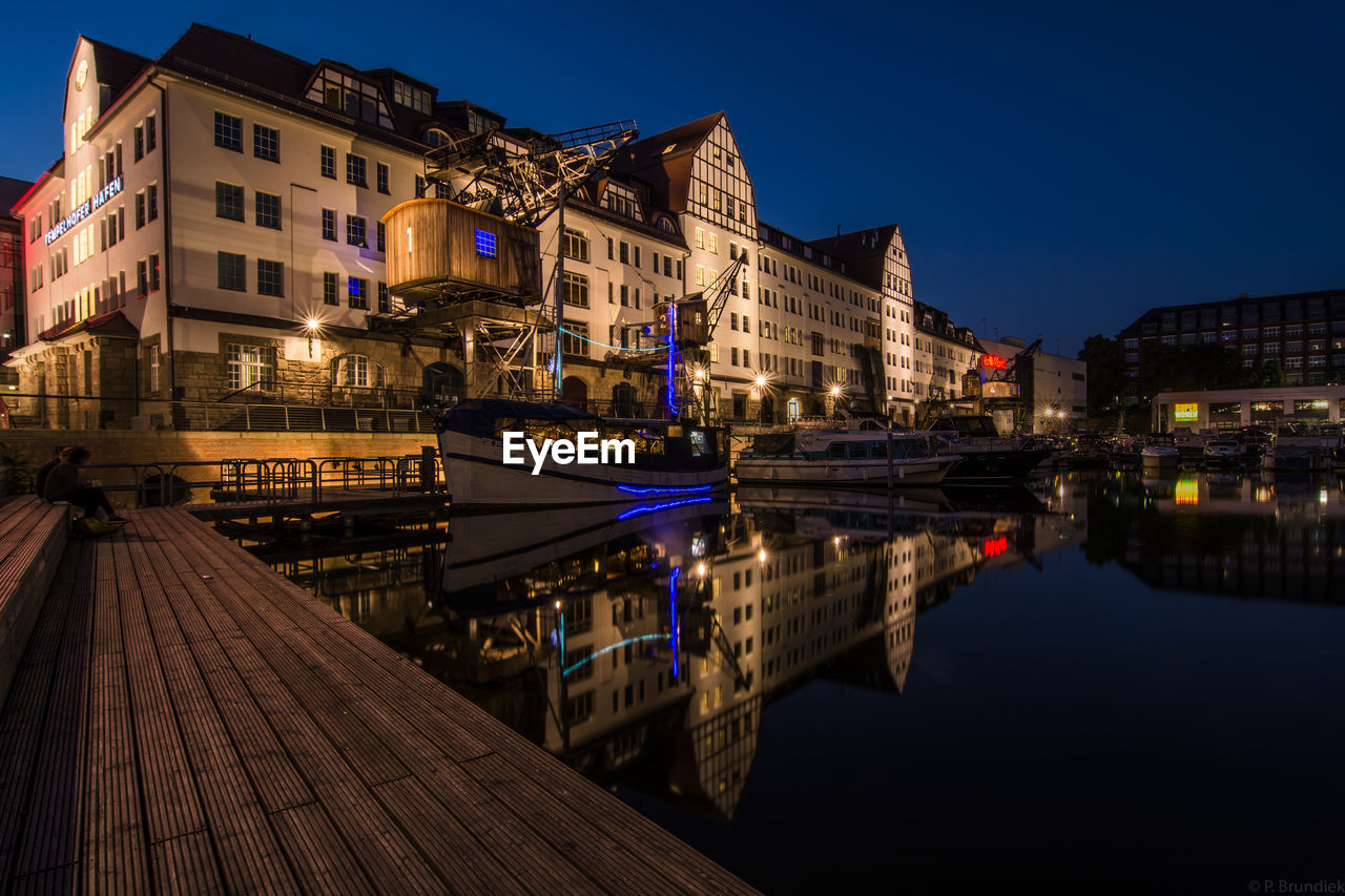 REFLECTION OF CITY IN WATER AT NIGHT