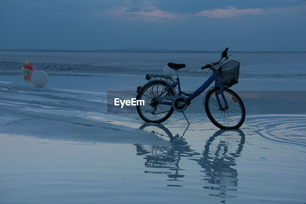 Bicycles on beach against sky