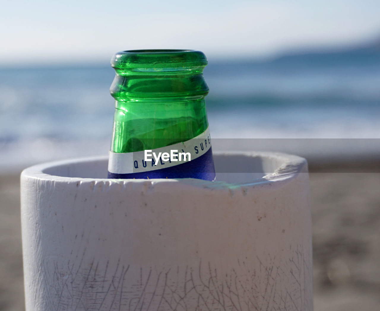 water, sea, beach, container, blue, bottle, land, nature, focus on foreground, green, no people, drinkware, drink, refreshment, close-up, food and drink, sand, outdoors, sky, day