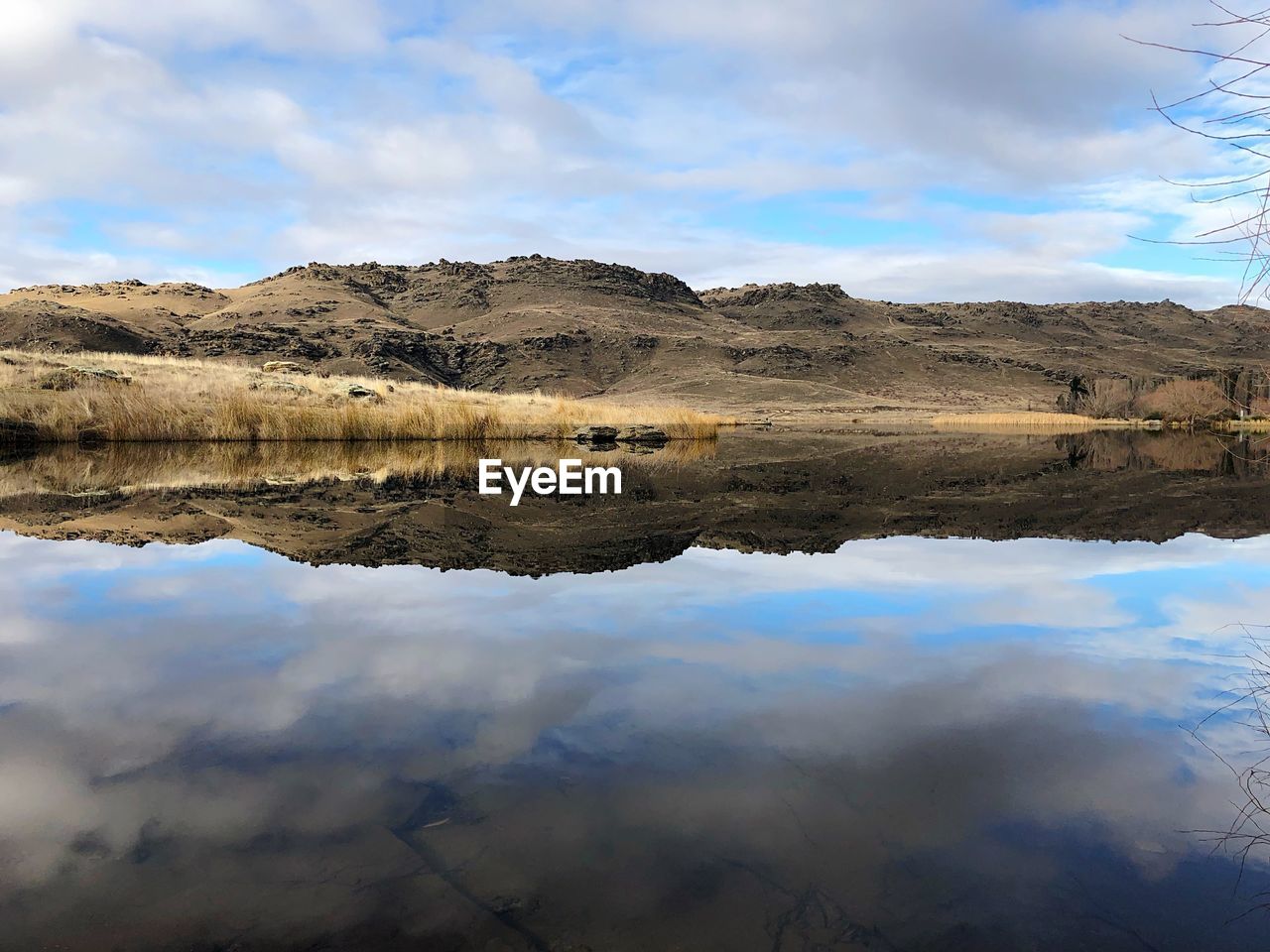 Scenic view of lake by mountain against sky