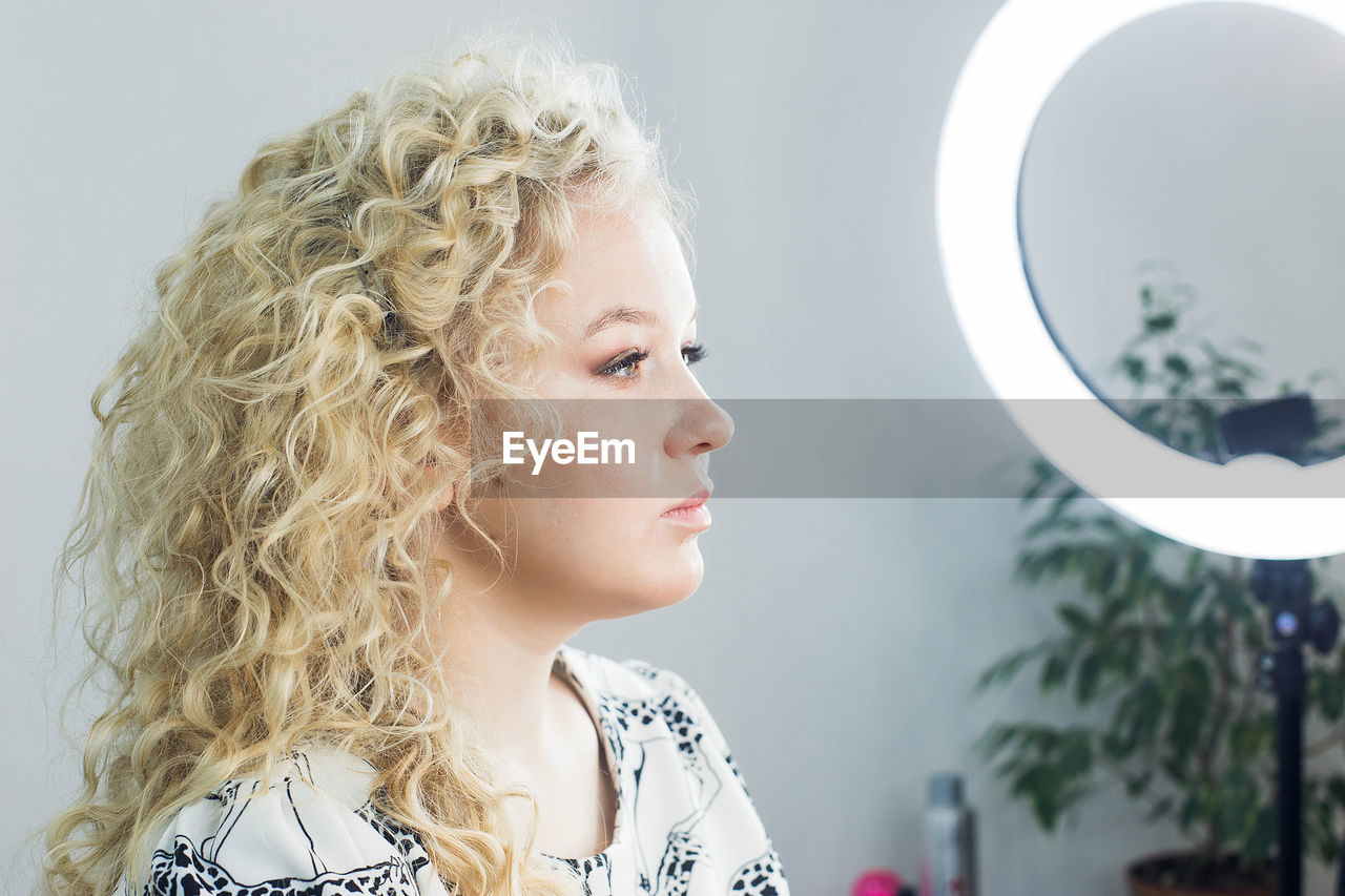 PORTRAIT OF A GIRL LOOKING AWAY AGAINST WHITE BACKGROUND