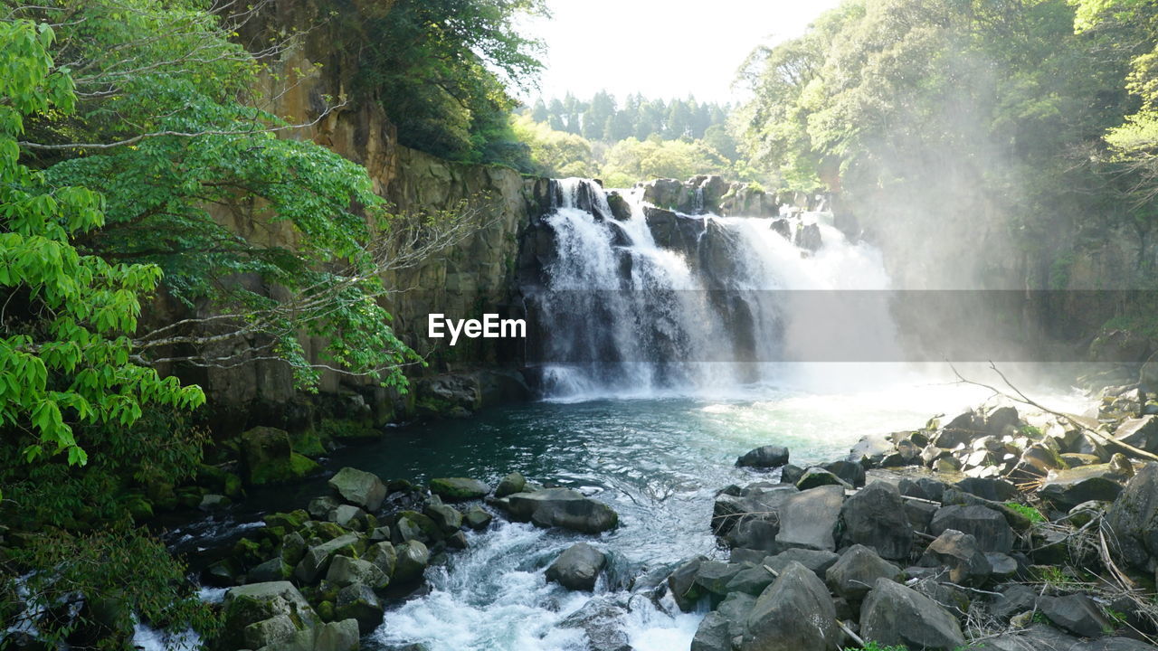 SCENIC VIEW OF WATERFALL AGAINST SKY