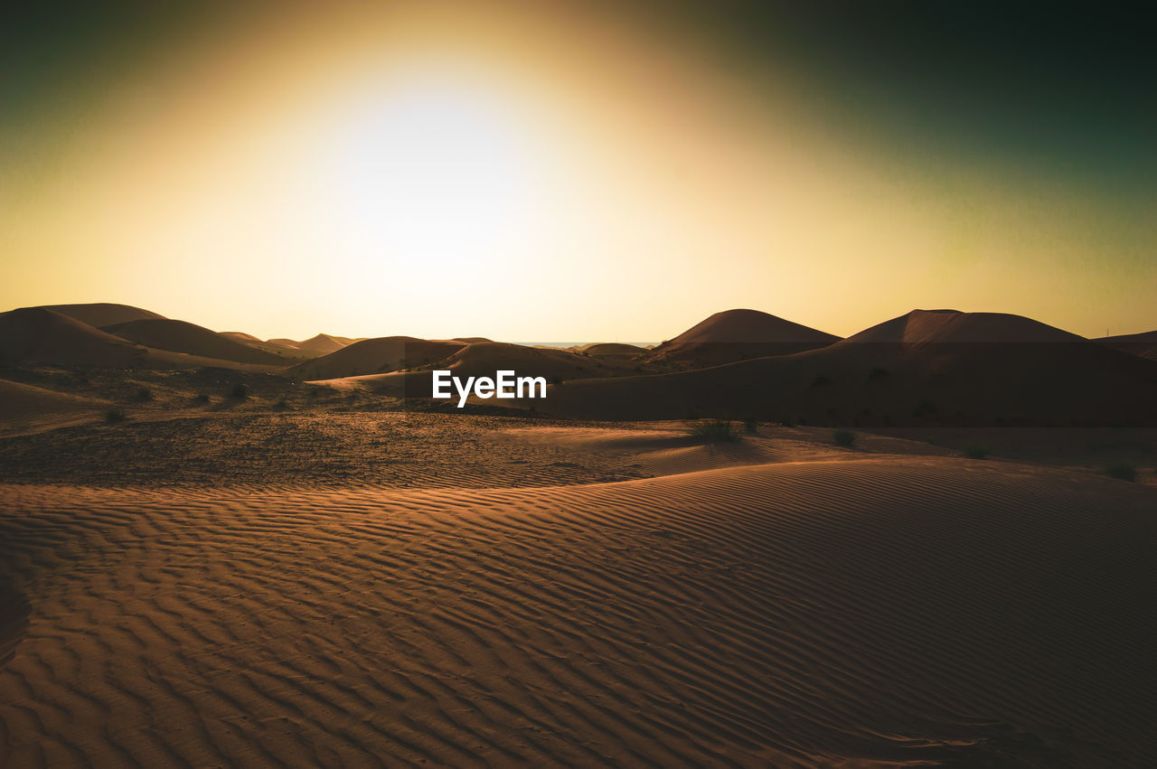 Scenic view of desert against sky during sunset