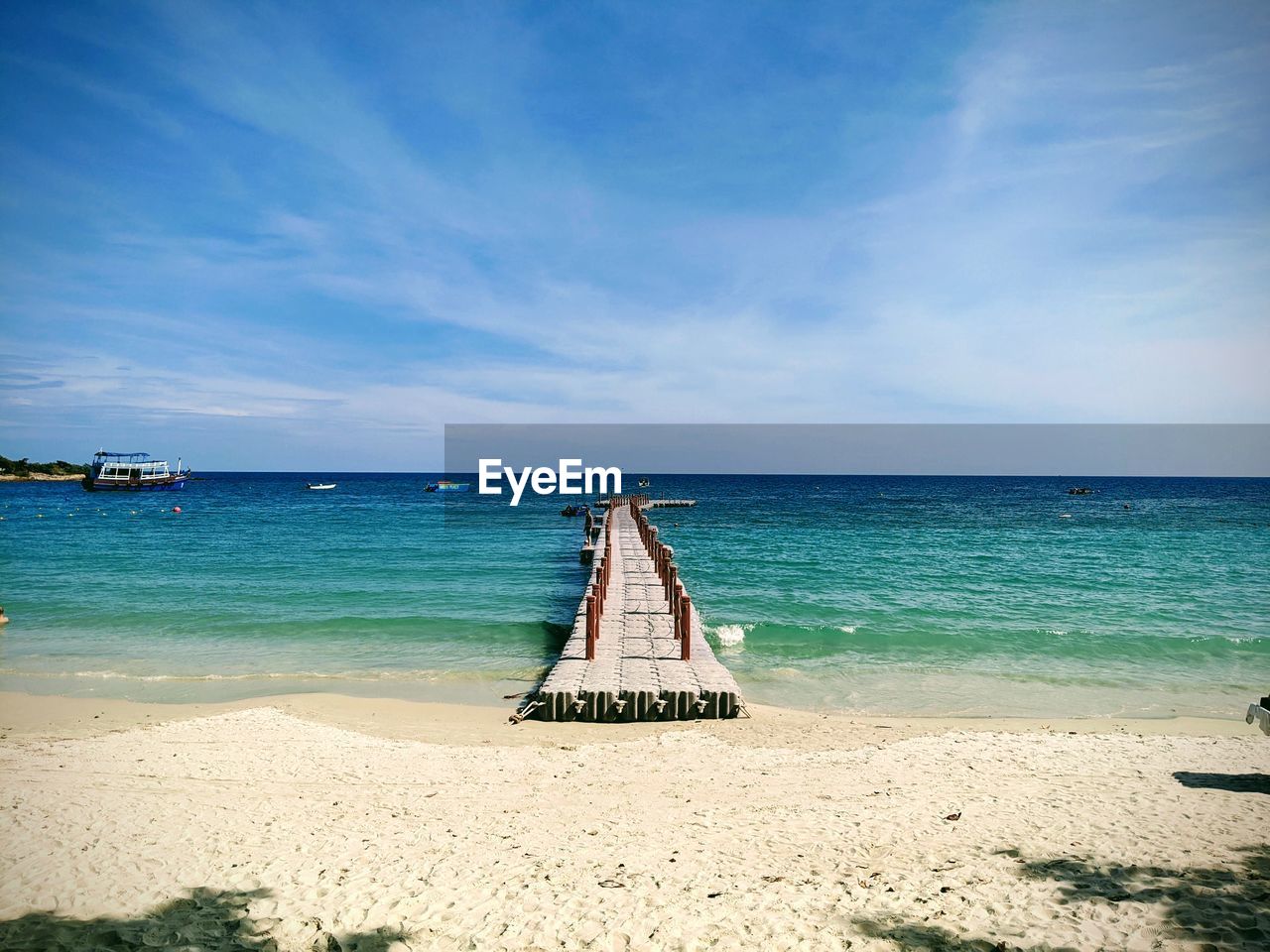 DECK CHAIRS ON BEACH AGAINST SKY