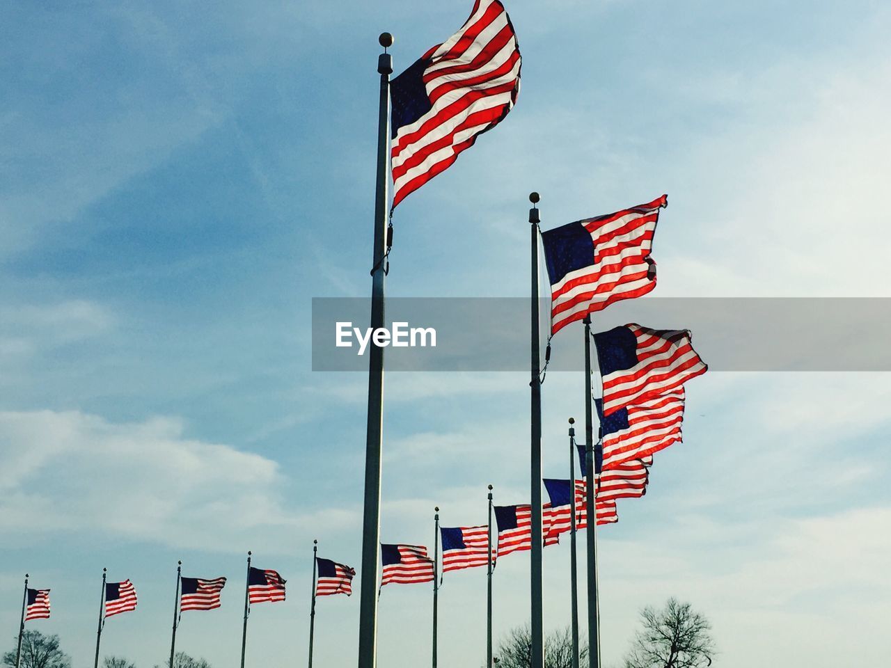 Low angle view of american flags against sky