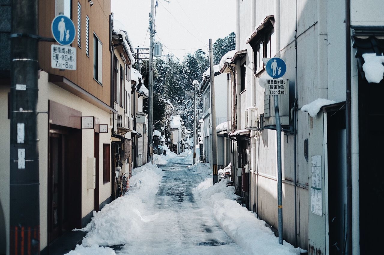 STREET AMIDST SNOW COVERED BUILDINGS