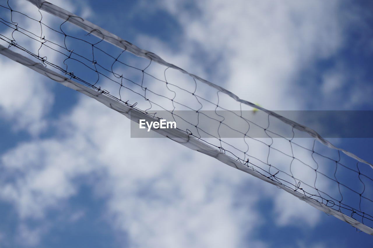 Low angle view of net against cloudy sky