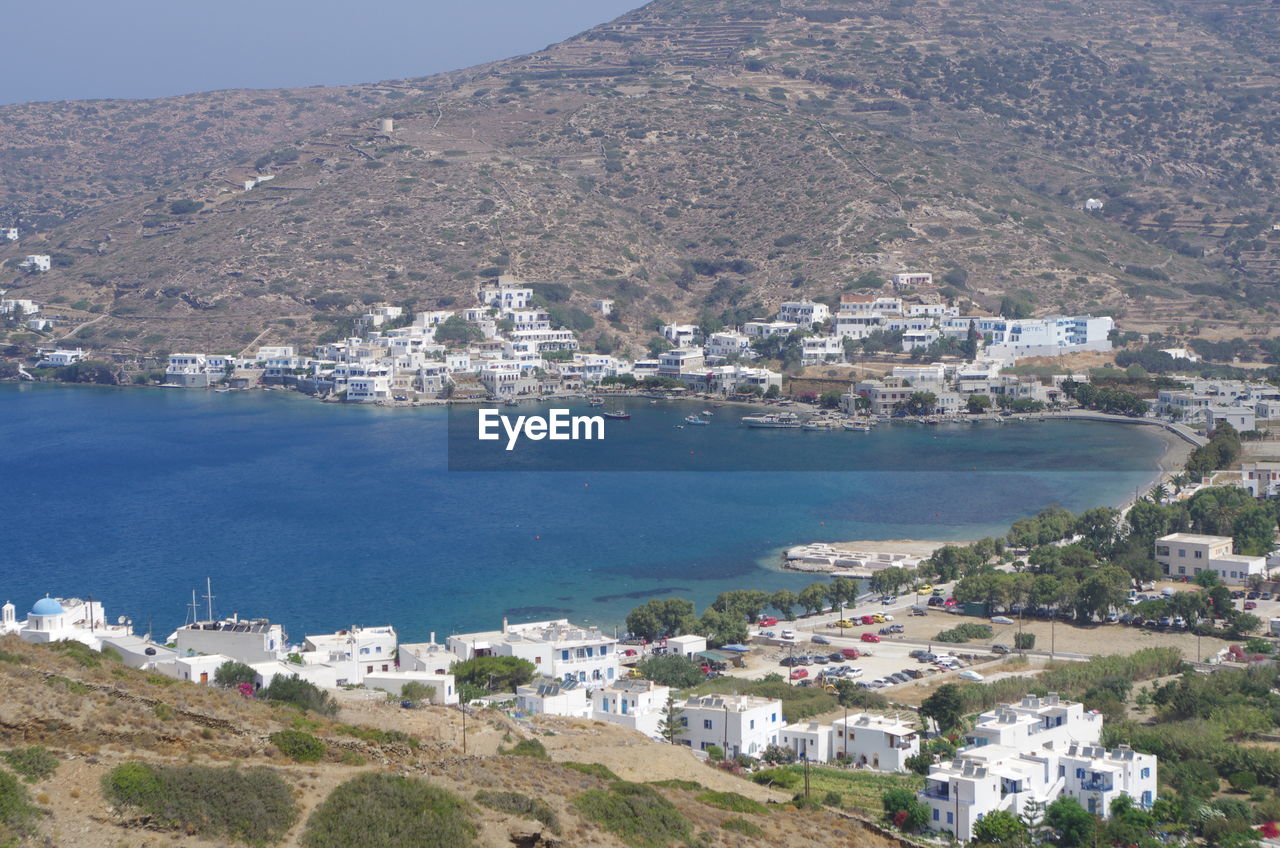 High angle view of town by sea against sky