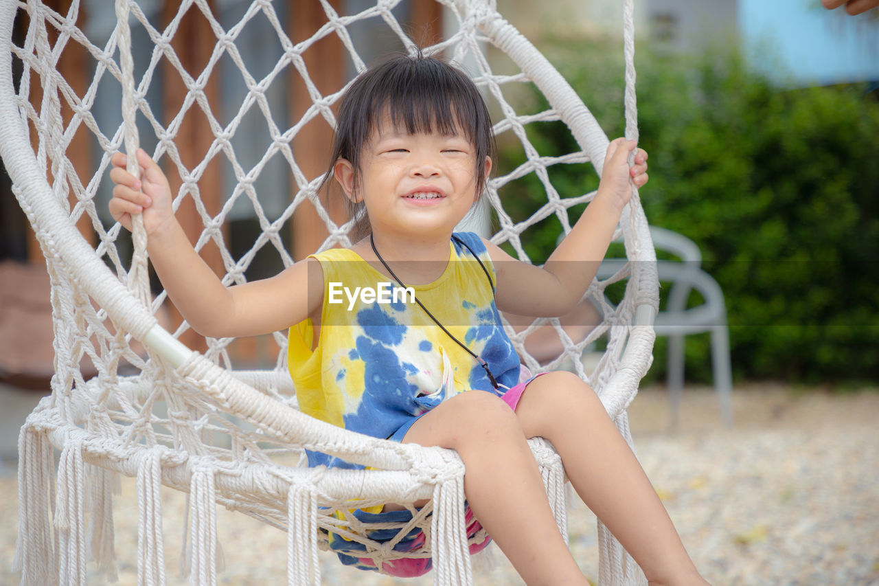 Smiling girl sitting on hammock