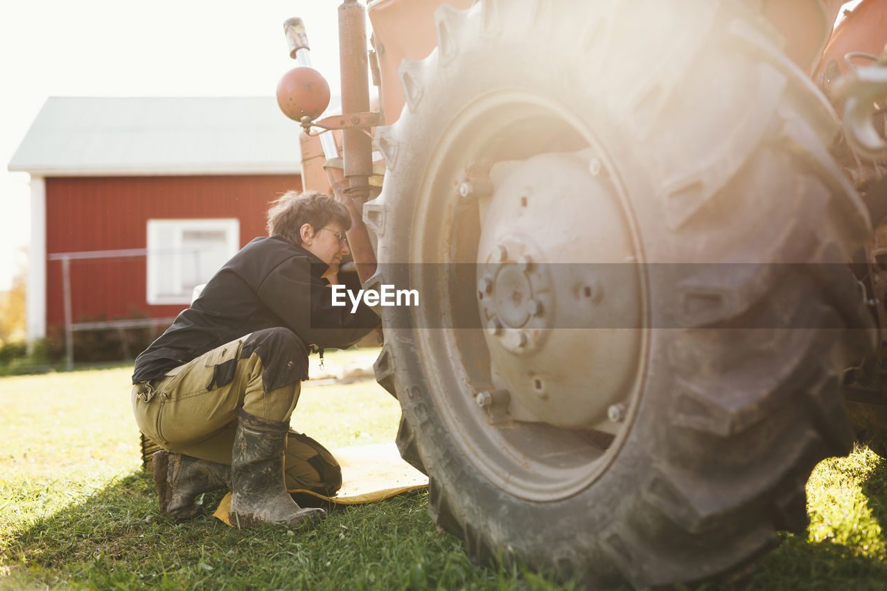 Woman repairing tractor