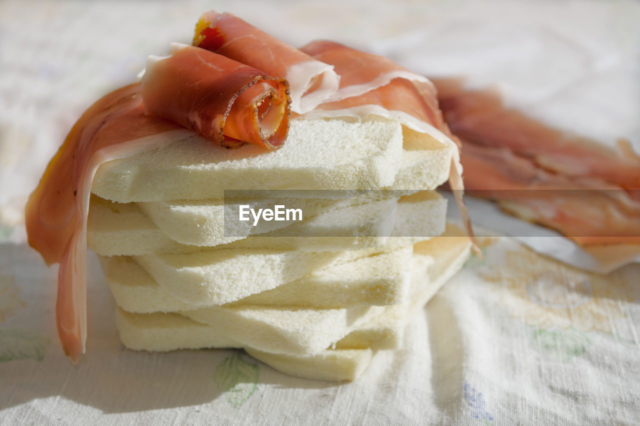 HIGH ANGLE VIEW OF HAND HOLDING BREAD