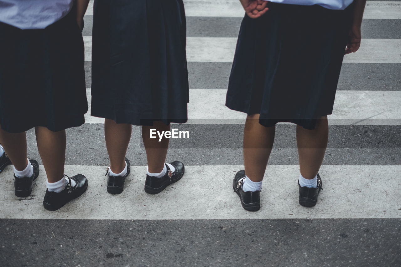 Low section of schoolgirls standing on street