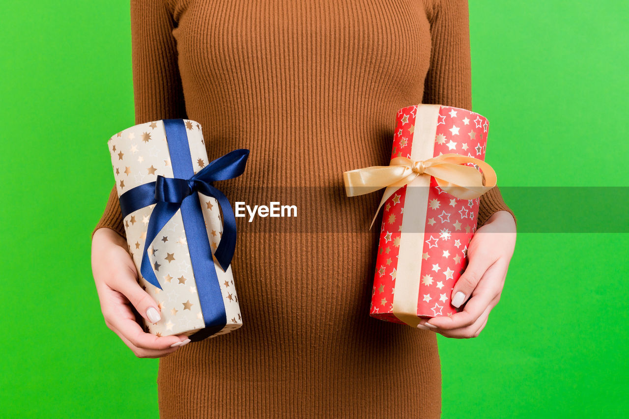 DIRECTLY ABOVE SHOT OF WOMAN HOLDING BOX AGAINST BLUE BACKGROUND