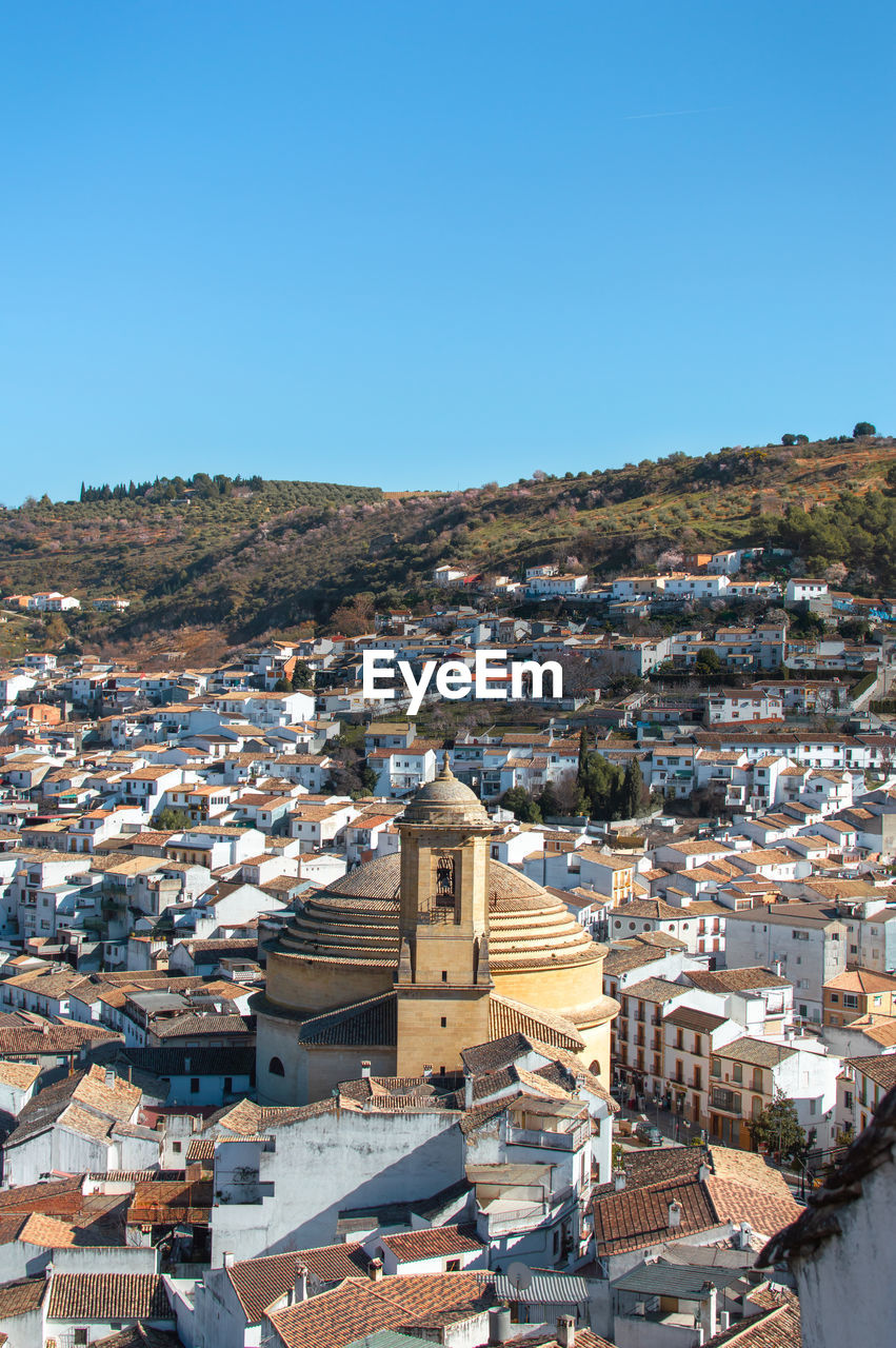 HIGH ANGLE SHOT OF TOWNSCAPE AGAINST BLUE SKY