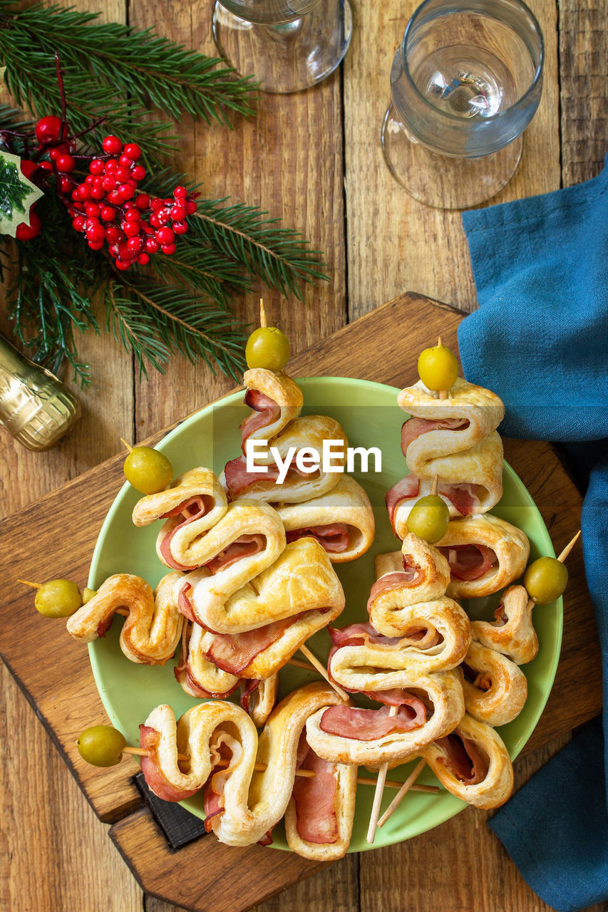 Christmas and new year food. holiday snack puff dough christmas tree with olive and bacon. 