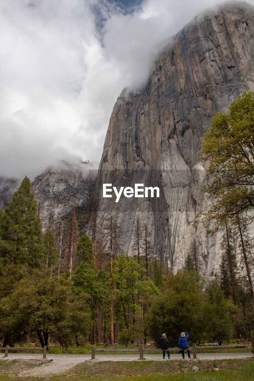 REAR VIEW OF PEOPLE WALKING ON MOUNTAIN