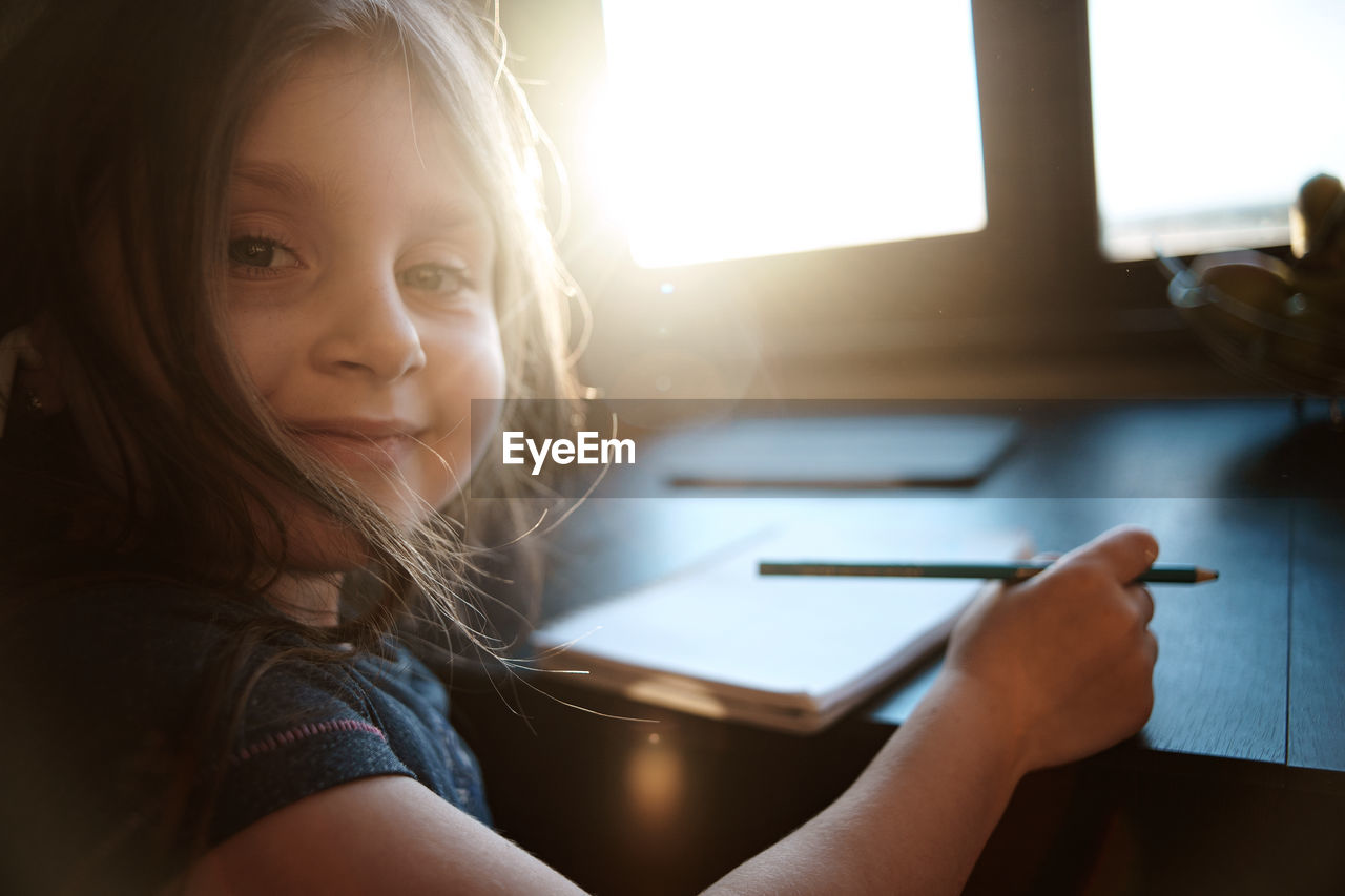 Portrait of girl reading book at home
