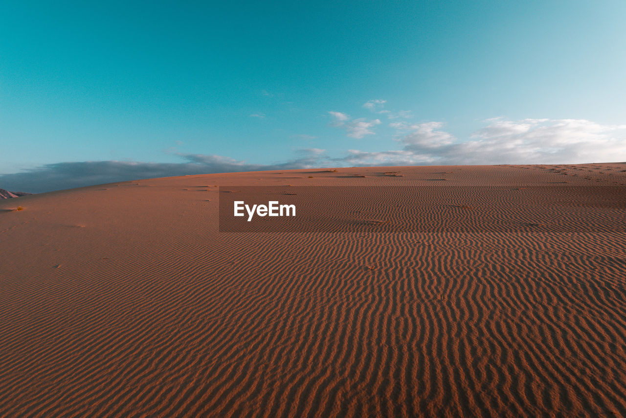 Scenic view of desert against blue sky