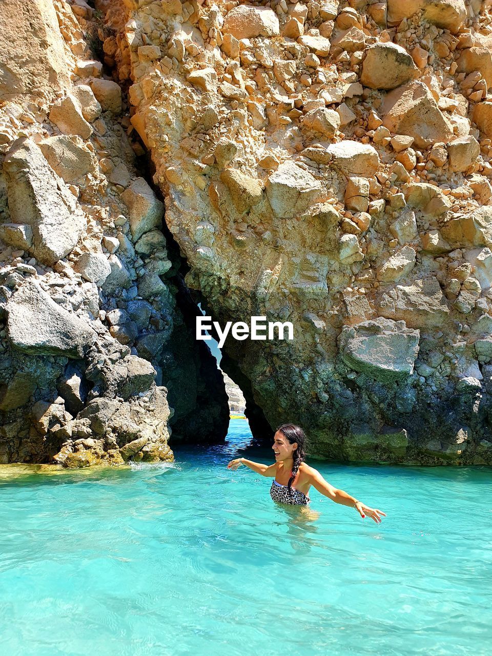 Woman with arms outstretched swimming in sea