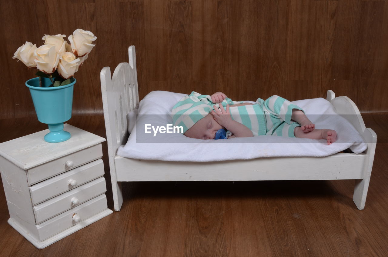 Close-up of baby boy sleeping on bed at home