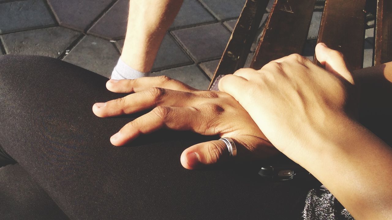 Cropped image of woman holding person hand