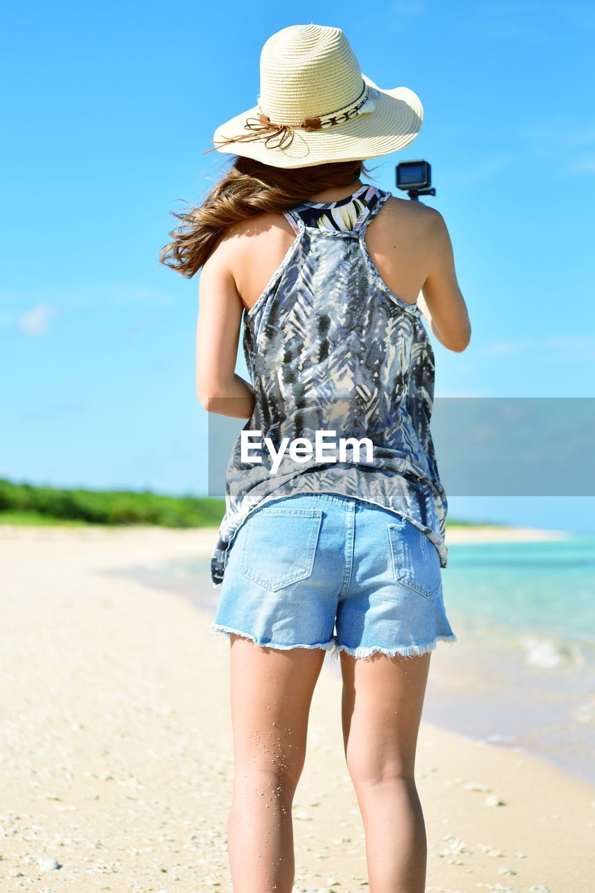 Rear view of woman wearing hat at beach