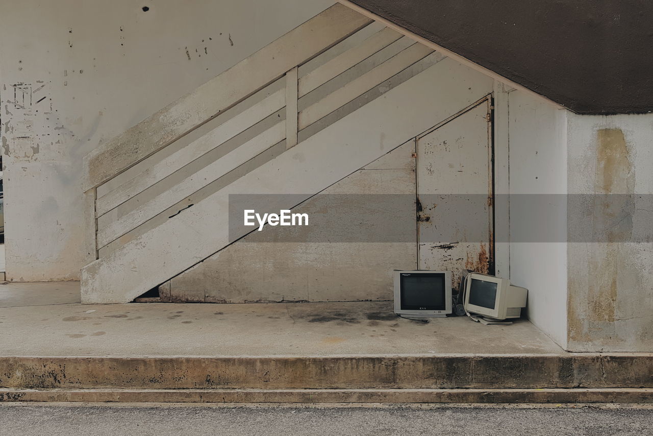 Abandoned television set and monitor by railing