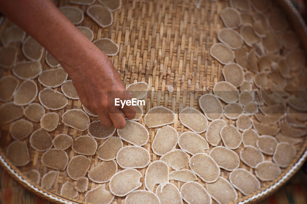 Cropped hand with food on wicker basket