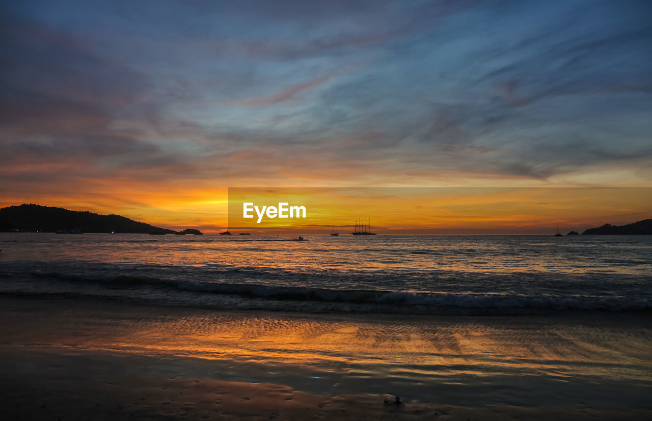 SCENIC VIEW OF BEACH AT SUNSET