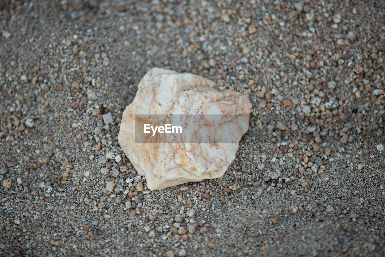 CLOSE-UP OF STONE ON SAND