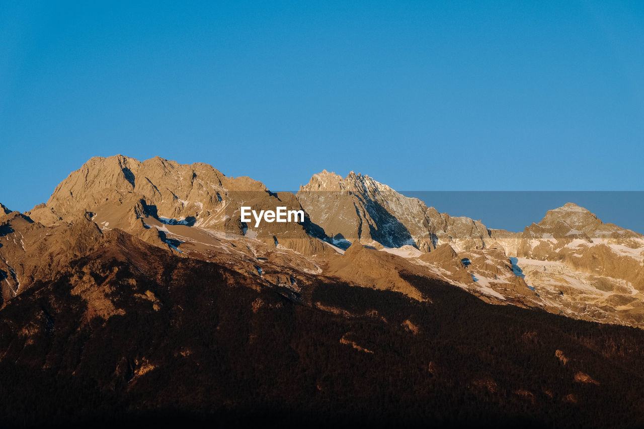 Low angle view of mountains against clear blue sky