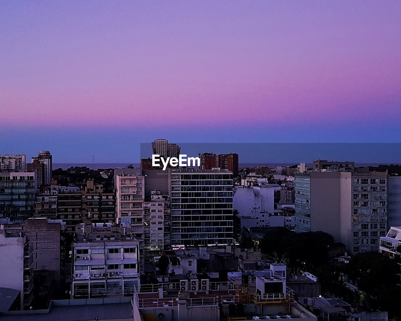 HIGH ANGLE VIEW OF BUILDINGS AGAINST ROMANTIC SKY