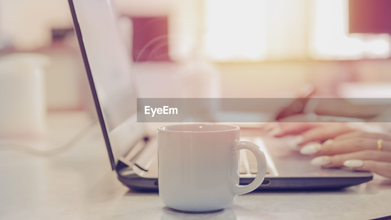 Woman with laptop. drinking coffee