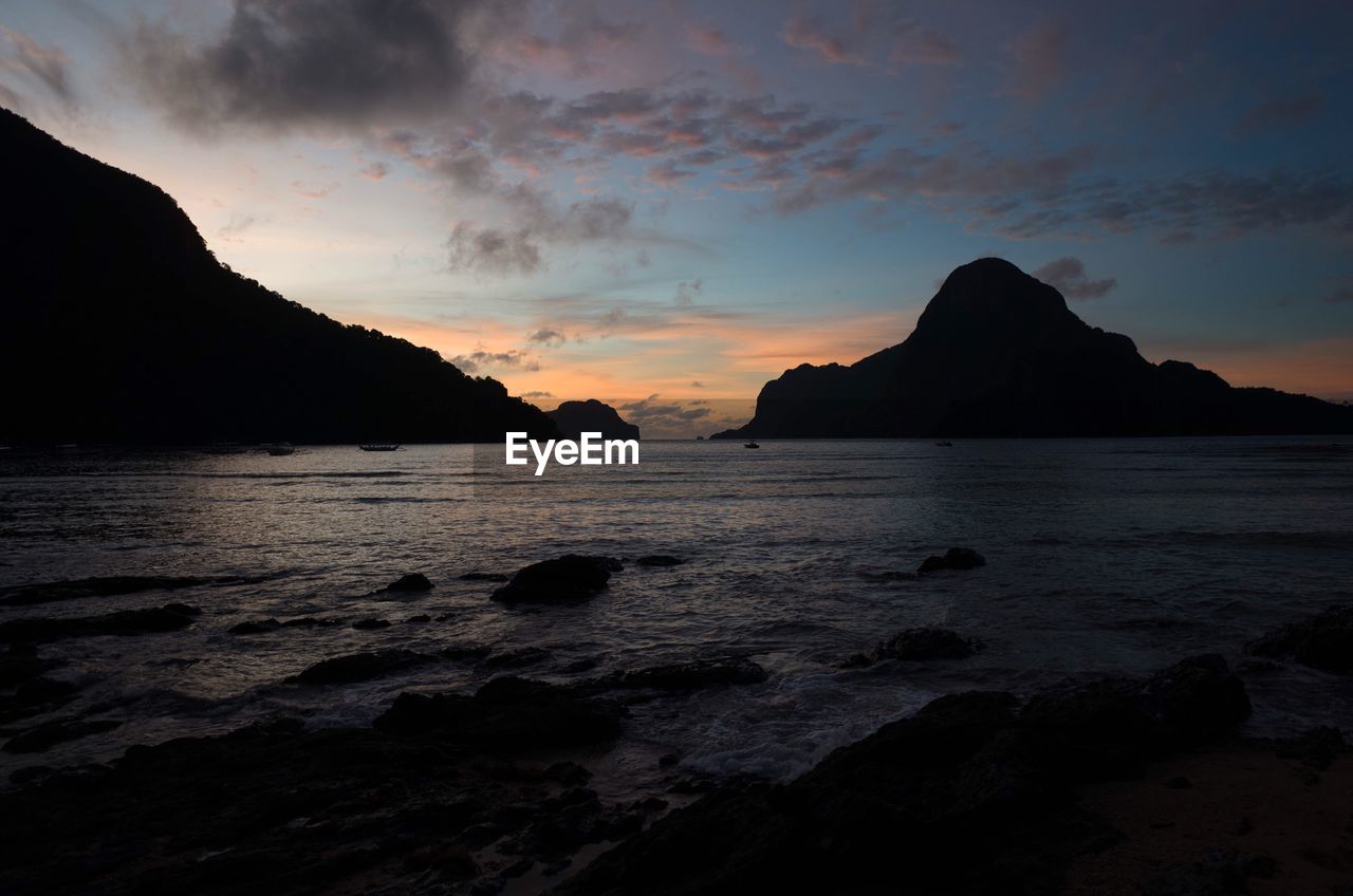 Scenic view of sea and mountains against sky