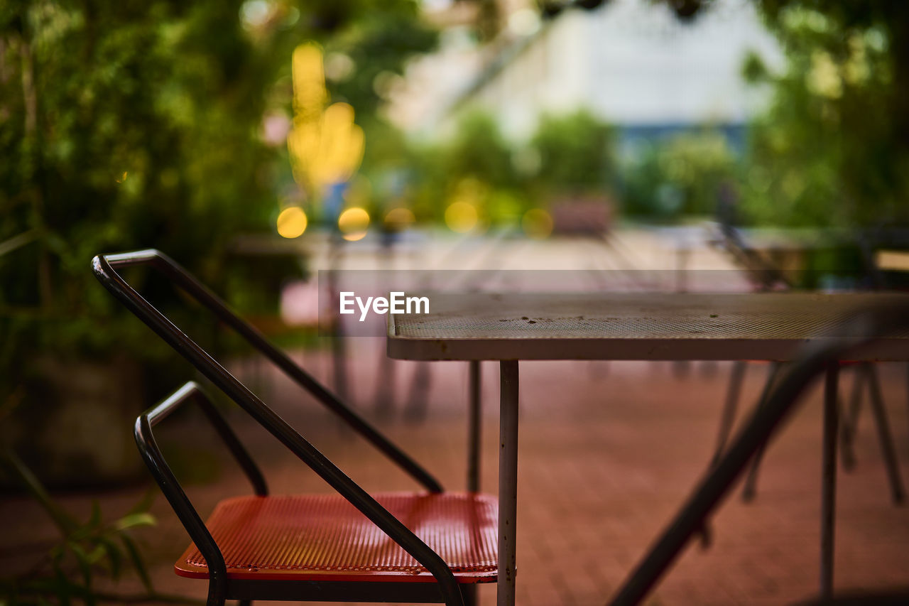 EMPTY CHAIRS AND TABLES IN PARK