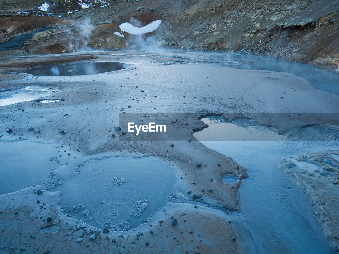 HIGH ANGLE VIEW OF FROZEN WATER ON ICE LAND