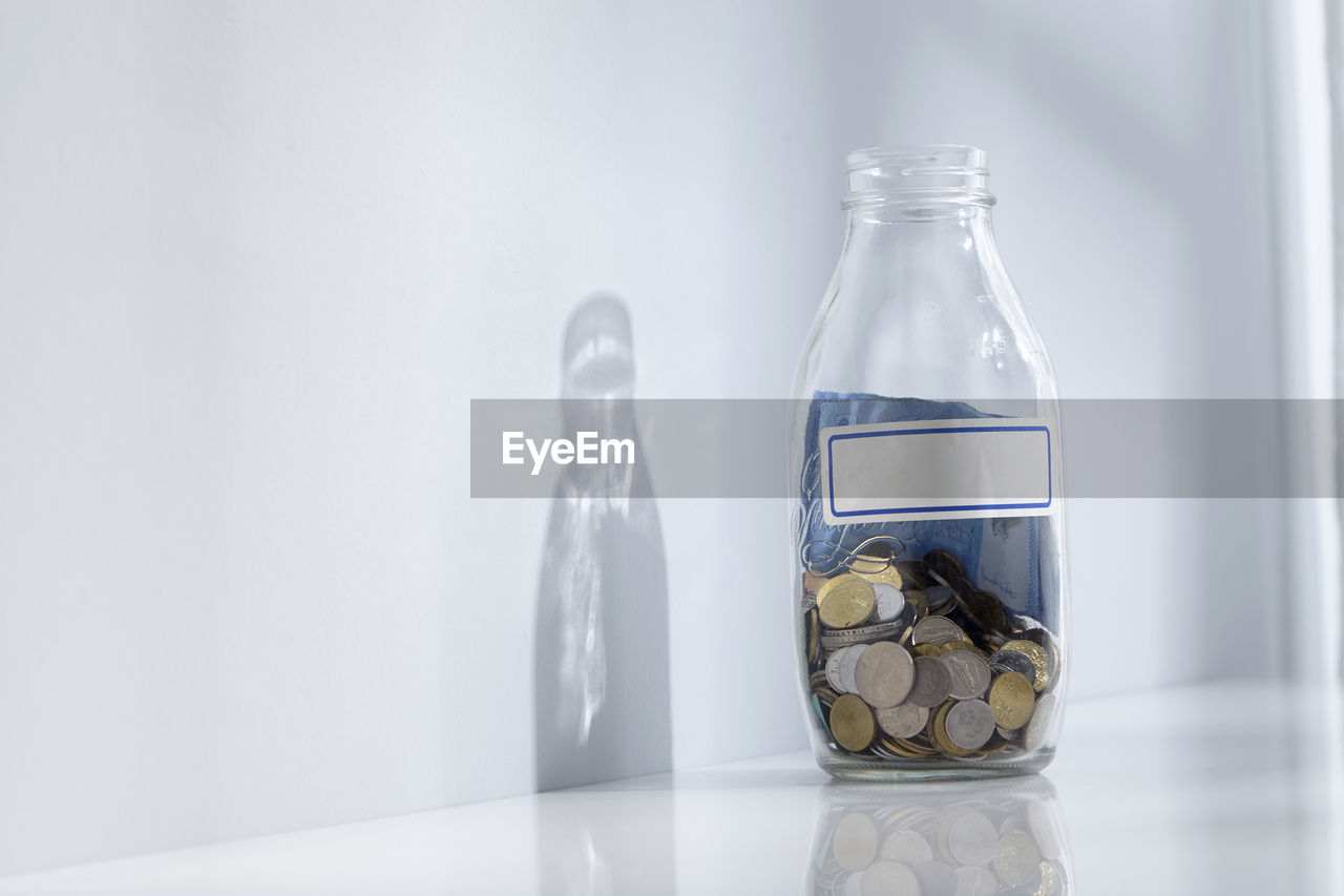 Bottle of saving jar on white table top