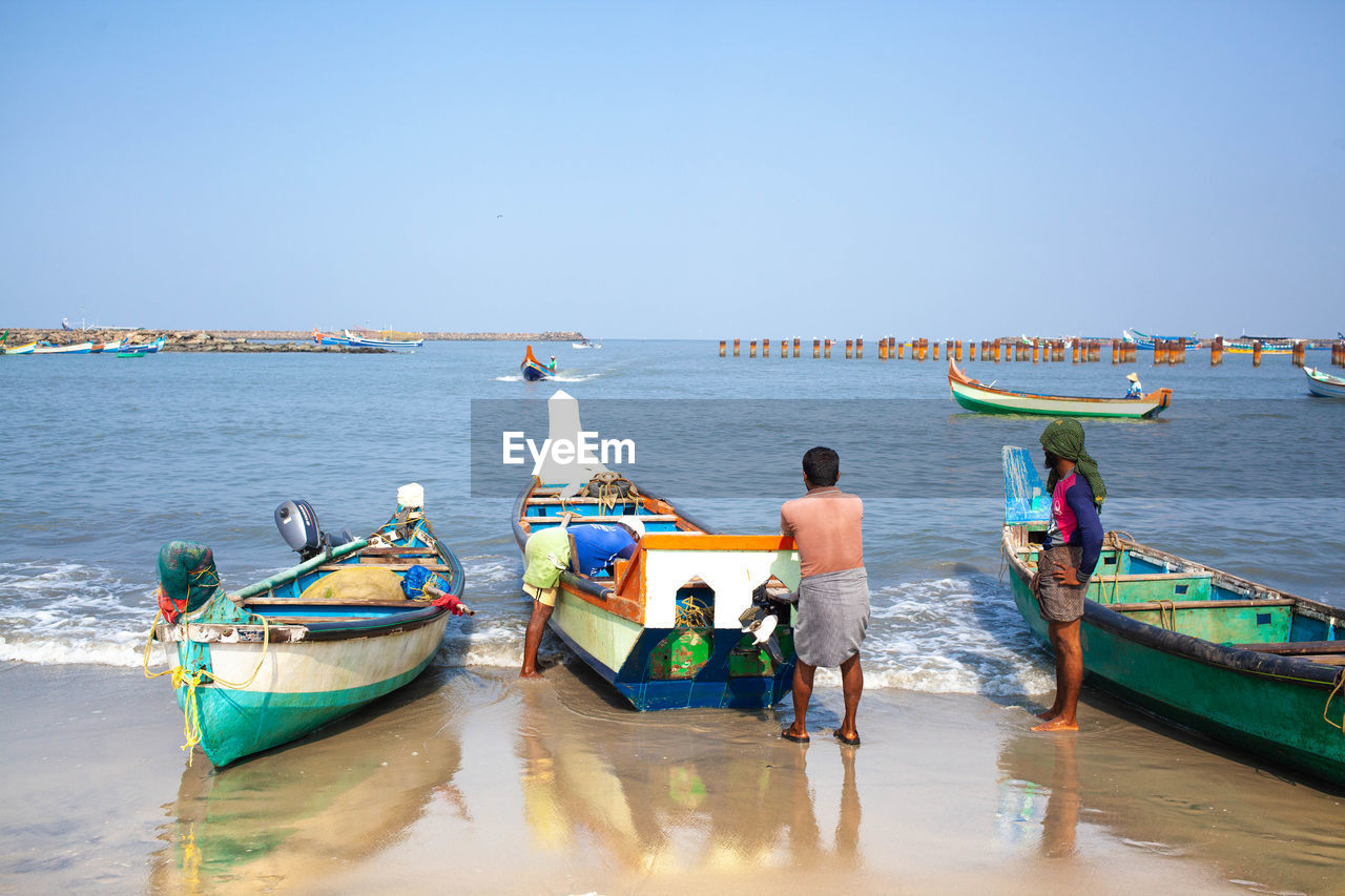 PANORAMIC VIEW OF PEOPLE ON BEACH AGAINST CLEAR SKY