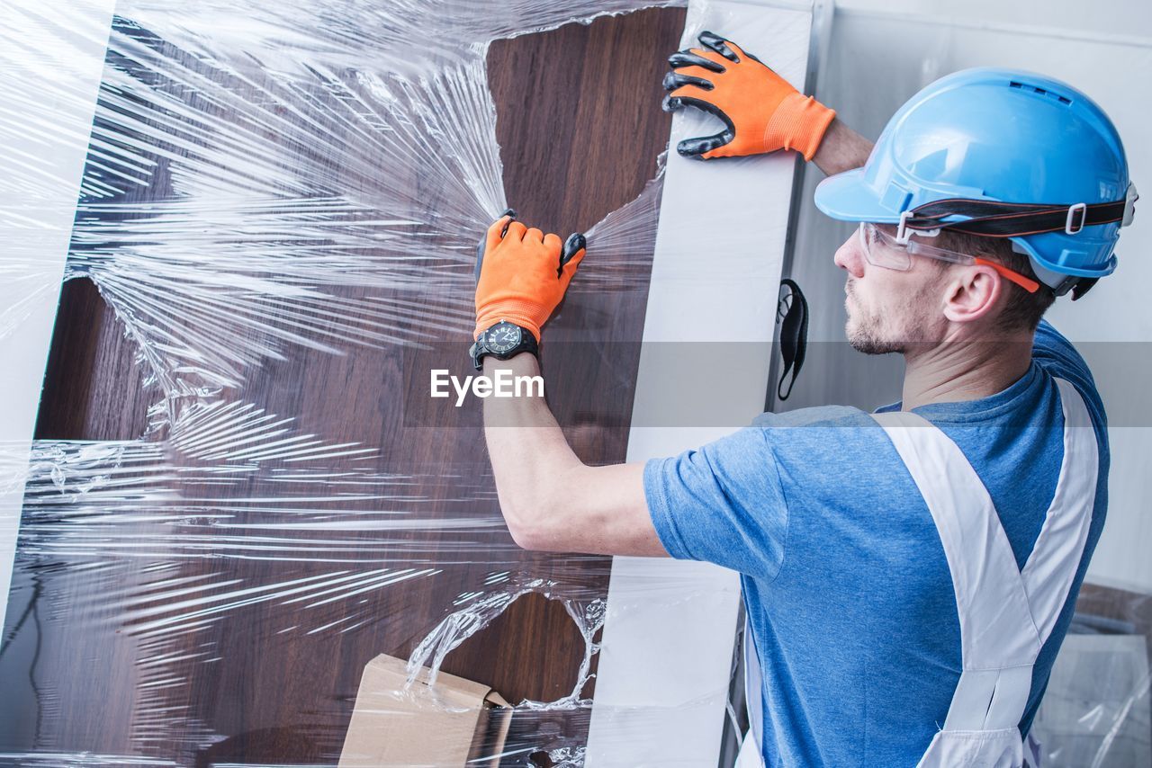 Manual worker removing plastic from door