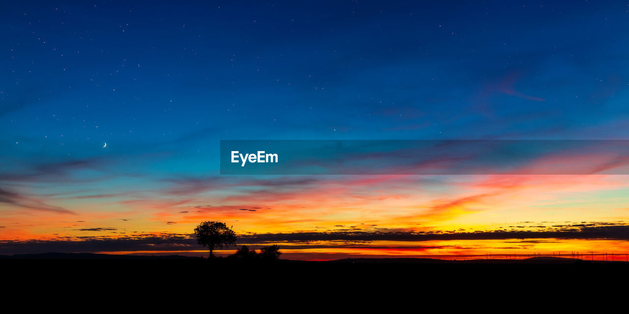 SCENIC VIEW OF SILHOUETTE LANDSCAPE AGAINST DRAMATIC SKY