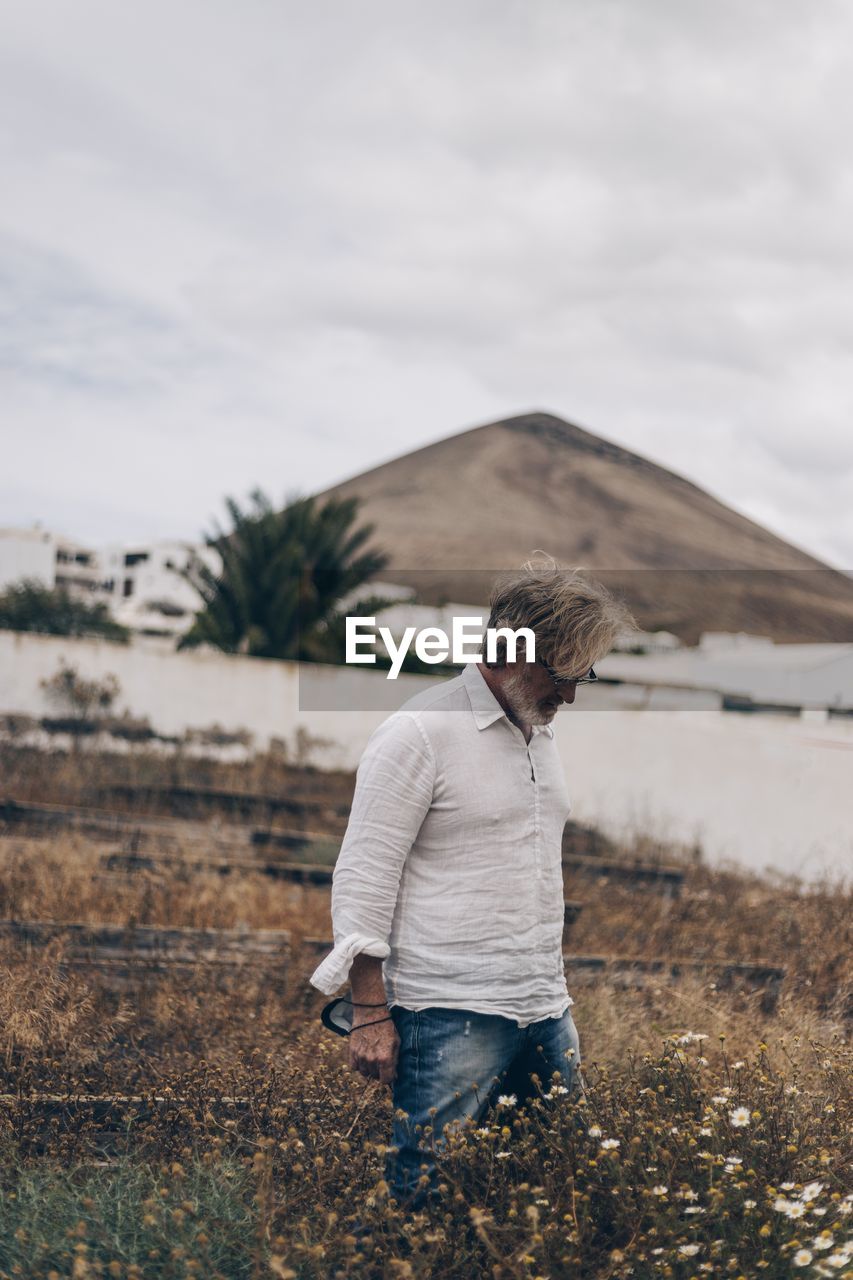 Man standing on field against sky